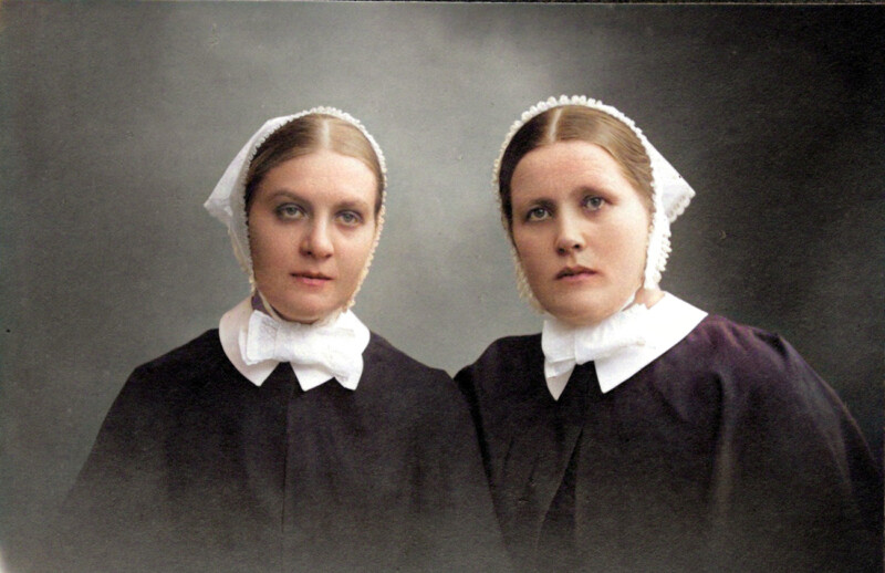 Kaksi diakonissaa. Heillä on vanhanaikainen asu päällään.