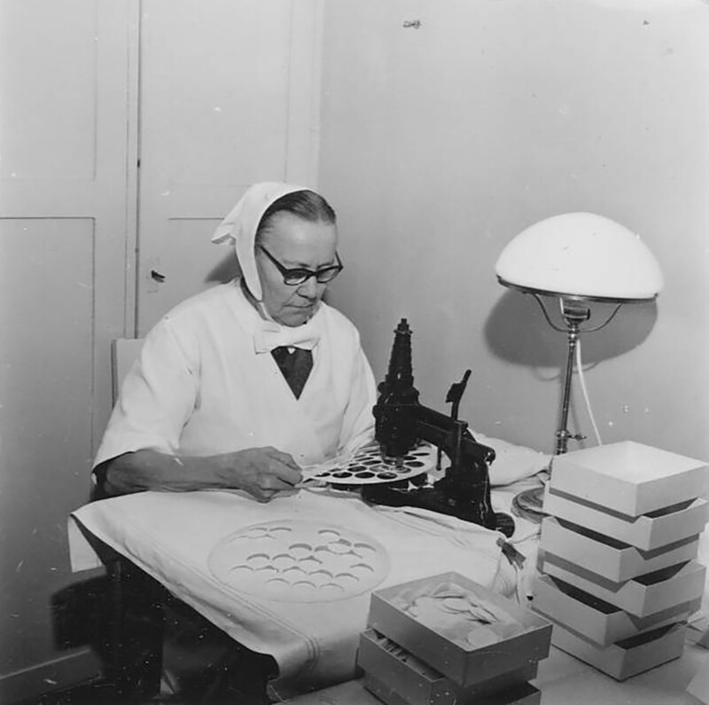 Nainen leikkaa ehtoollisleipi leikkurilla.