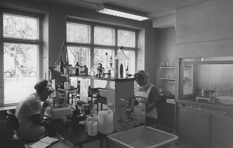 Laboratoriotyöntekijät työskentelevät Diakonissalaitoksen sairaalan laboratoriossa, jossa näkyy erilaisia laboratoriovälineitä ja laitteita.