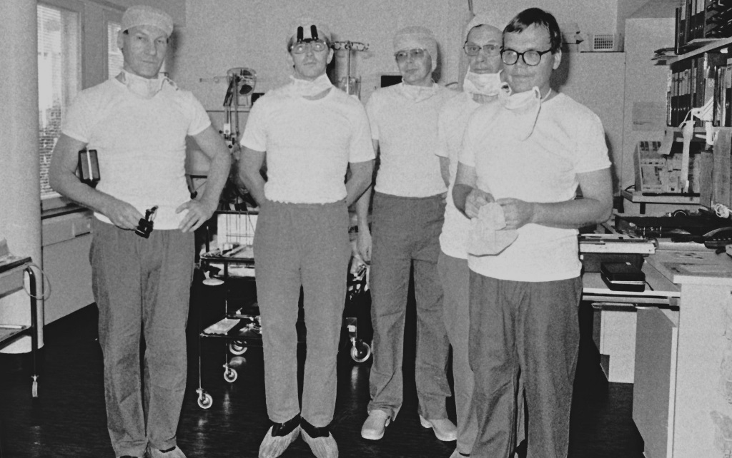 Mustavalkoinen kuva, jossa viisi lääkäriä valmiina sydänleikkaukseen Diakonissalaitoksen sairaalan Sydänkeskuksessa vuonna 1988.
