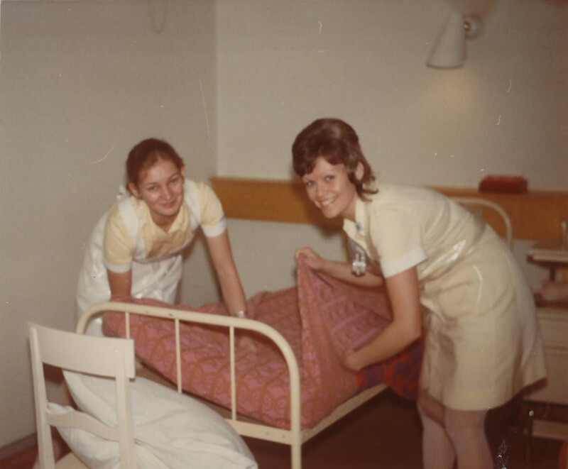 Kaksi sairaanhoitajaa järjestää sairaalasängyn vuodevaatteita Diakonissalaitoksen sairaalan huoneessa.