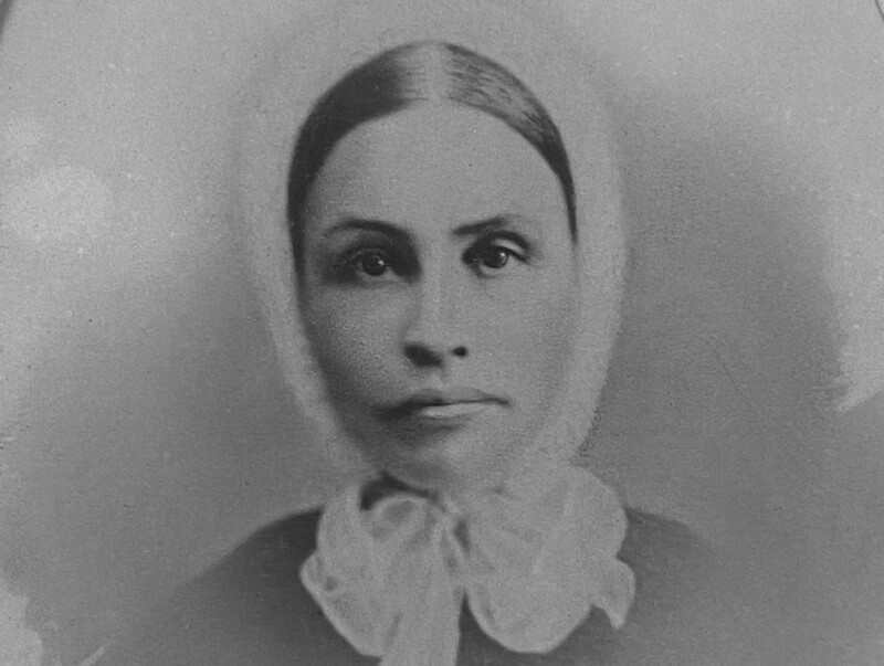 Nainen, jolla on vanhanmallinen diakonissan päähine päässään.