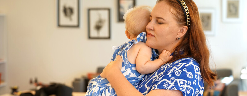 Äiti halaa pientä tytärtä sylissään.