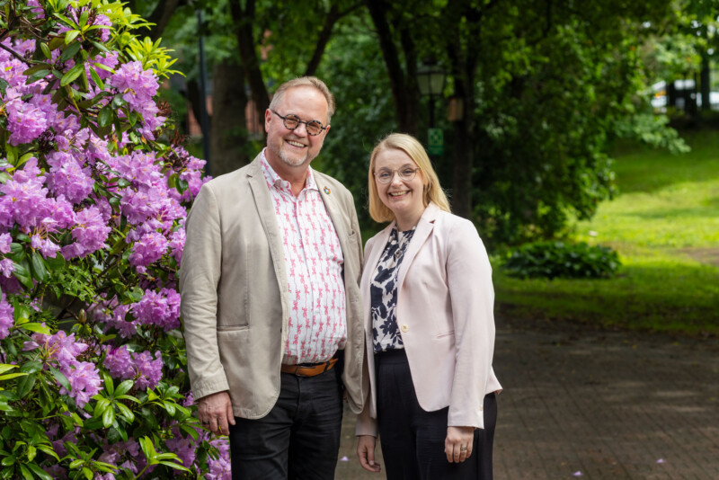 Mies ja nainen katsovat hymyillen kameraan.