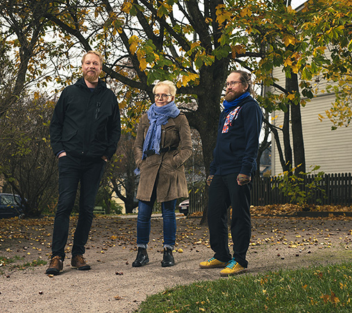 Kolme ihmistä seisoo vierekkäin.