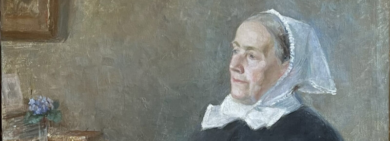 Muotokuva naisesta, jolla valkoinen pitsikoristeinen myssy päässään ja tumma vaate, taustalla vaaleanharmaa seinä ja pieni kukkakimppu.