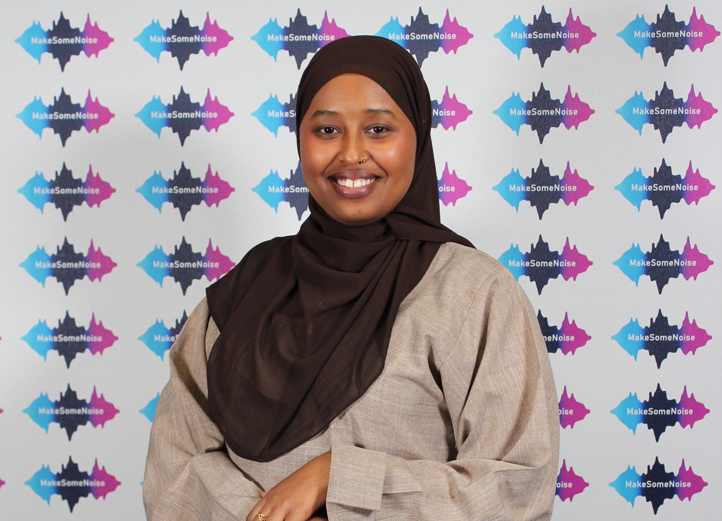 Nuori nainen katsoo hymyillen kameraan.