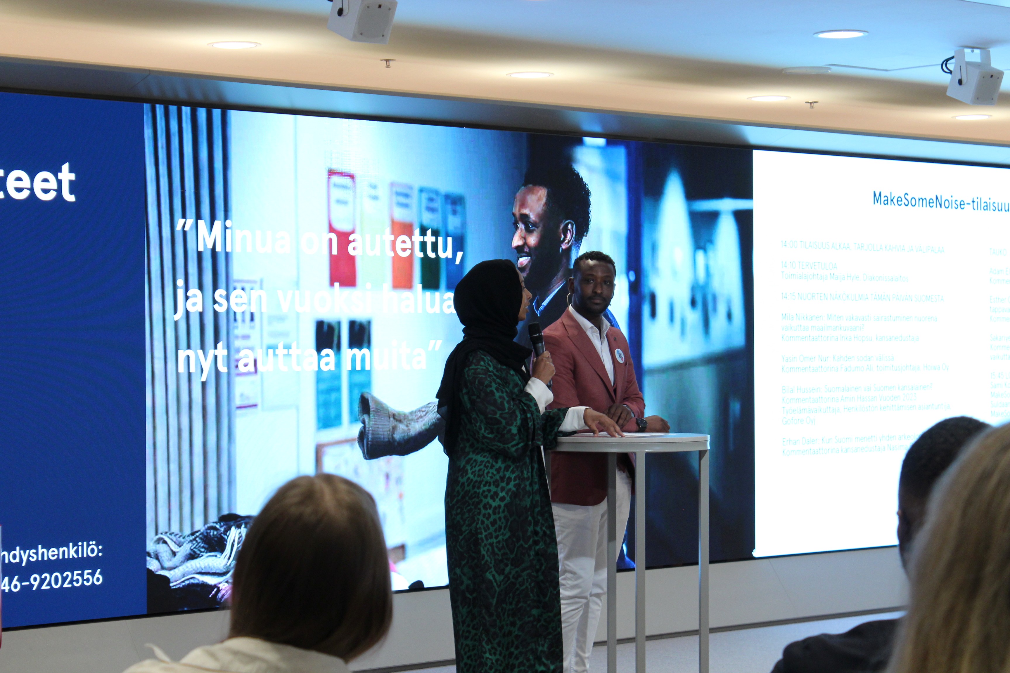 Kaksi nuorta keskustelee esiintymislavalla.