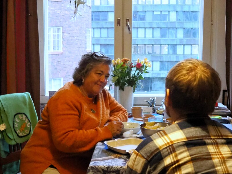 Nainen ja mies istuvat kahvipöydän ääressä keskustelemassa.