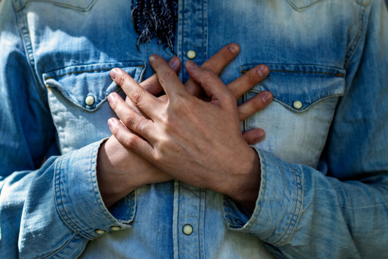 Mies on ristinyt kädet rinnalleen.