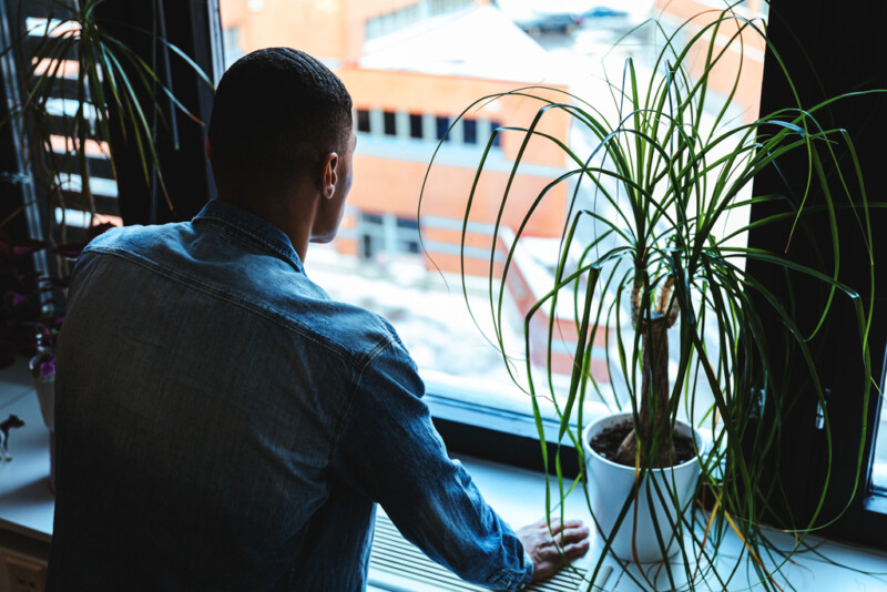 Henkilö katsoo ulos ikkunasta.