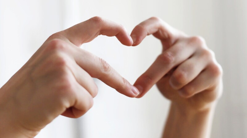 Kädet, jotka muodostavat sormillaan sydämen.