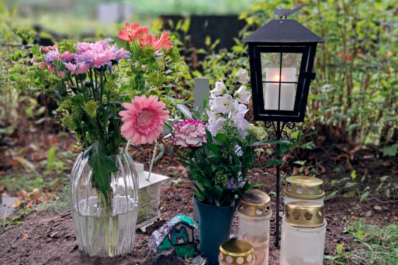 Kukkia ja kynttilöitä haudalla