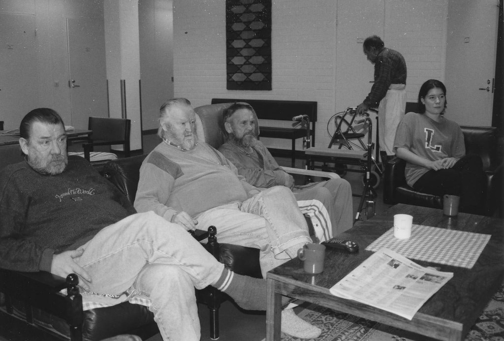 Henkilöitä matalan sohvapöydän ääressä.