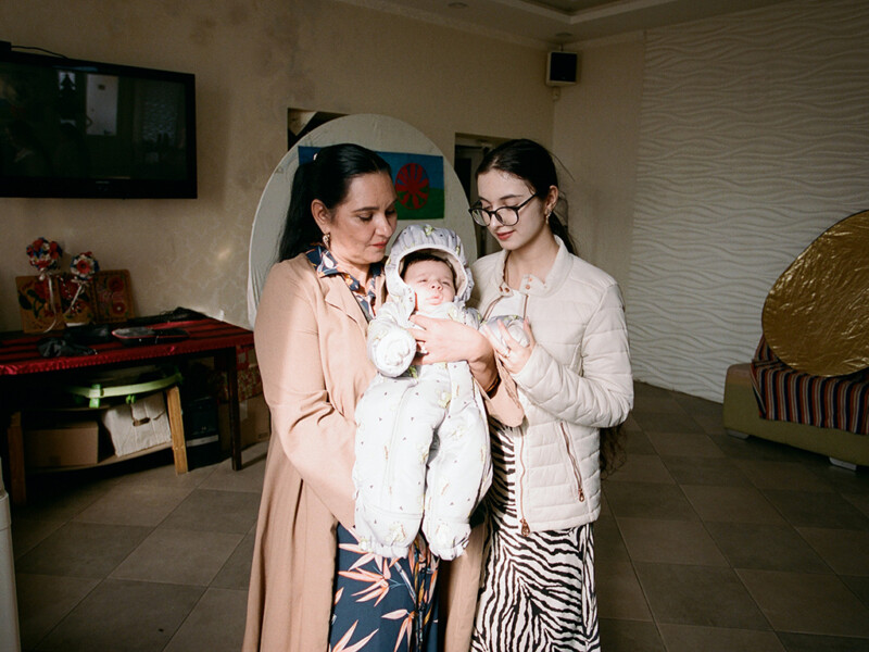 Äiti ja tytär pitelevät vauvaa sylissään.