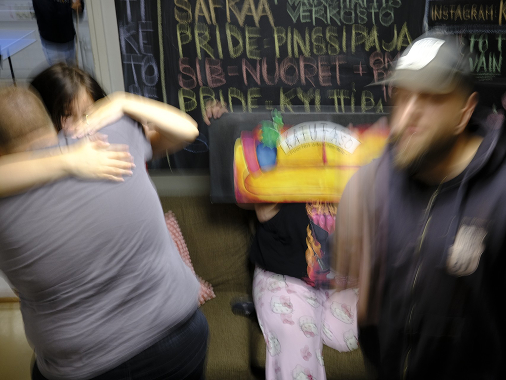 Heilahtaneessa kuvassa nuoret aikuiset halaavat toisiaan.