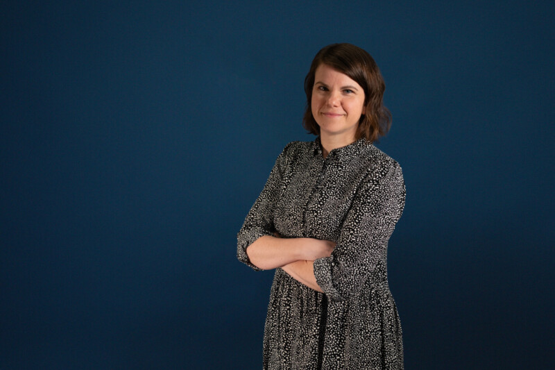 Kuva Tuuli Shinyellasta kasvot kameraan päin sinistä taustaa vasten