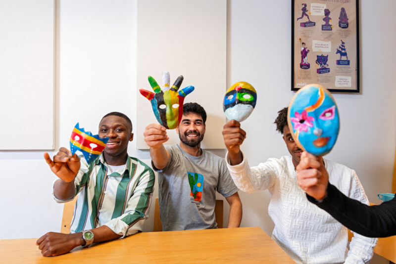 Neljä nuorta iloisina pöydän ympärillä.