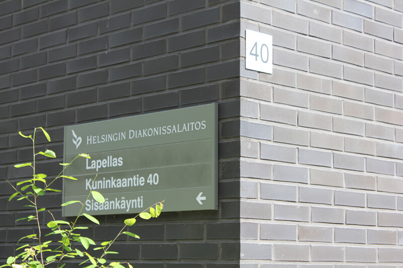 Rakennuksen kulma, jossa on kyltti Helsingin Diakonissalaitoksen Lapellas-lastensuojeluyksikköön osoittavalla tekstillä ja osoitteella Kuninkaantie 40.
