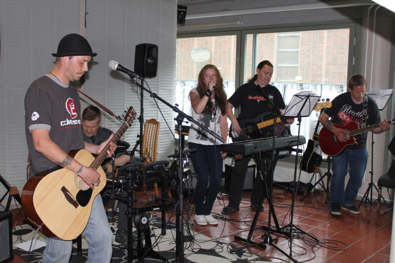 Bändi esiintyy sisätiloissa, mukana akustinen kitara, rummut, laulu, sähkökitara ja kosketinsoitin.